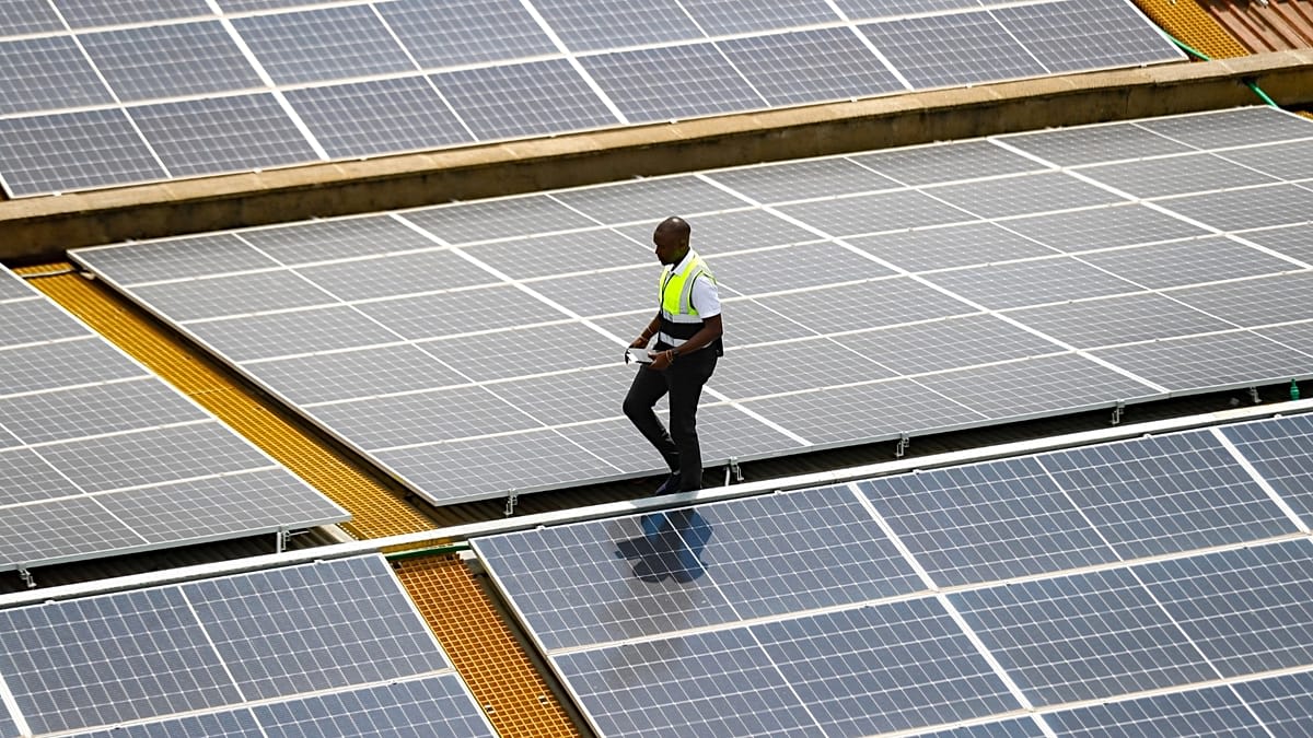 Solar panels on European rooftop capturing sunlight with blue sky above