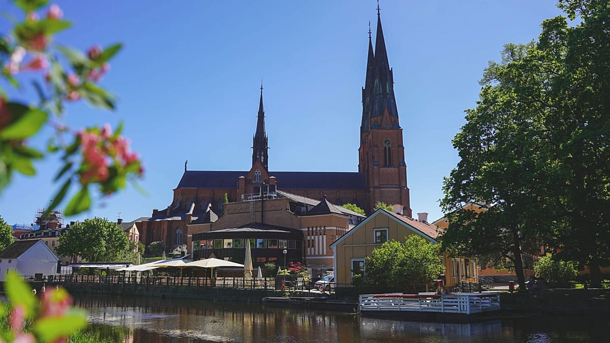 Red binocular viewer pointing toward historic Uppsala Cathedral's architectural details in Sweden