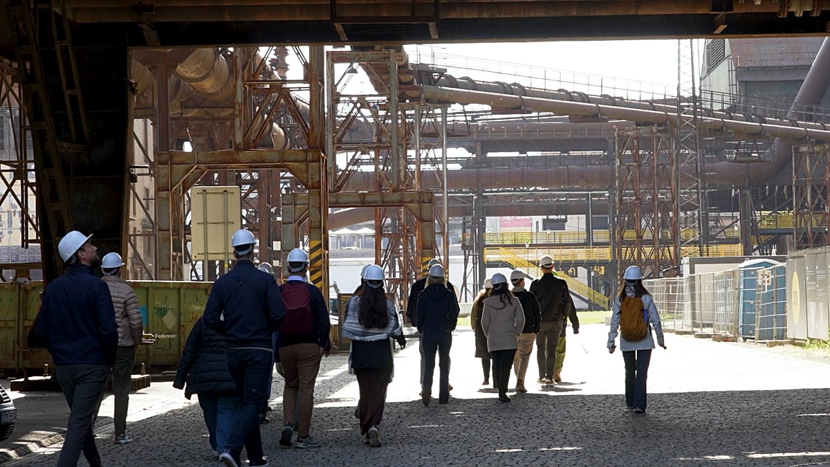 Visitors touring inside converted industrial steelworks with preserved machinery and modern viewing platforms