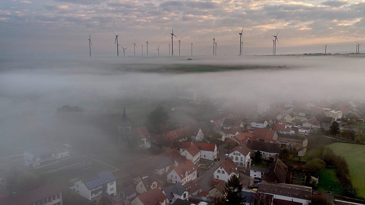 Solar panels and wind turbines generating clean electricity against blue sky backdrop