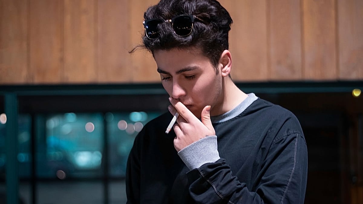 No smoking sign with young people walking freely in smoke-free public space