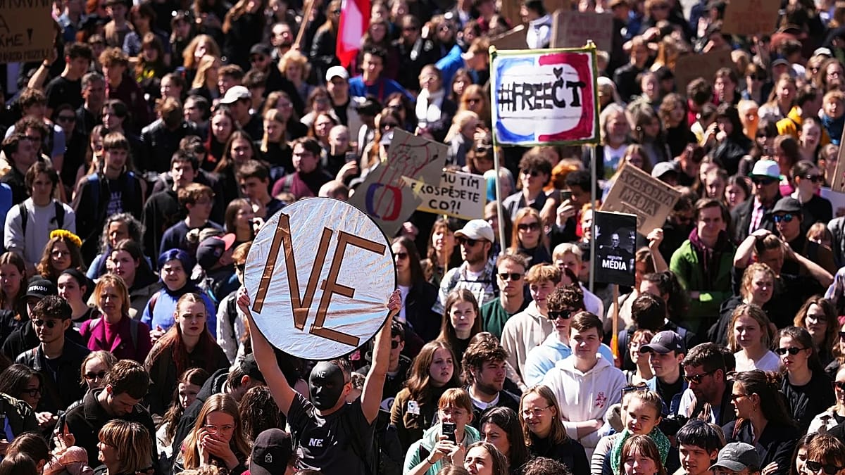 Large crowd of Czech students marching through Prague streets holding signs supporting public media independence