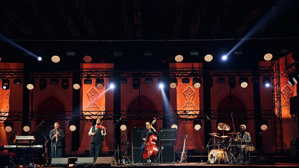 Thousands of people gathered on grass watching jazz performance on outdoor stage in Tashkent
