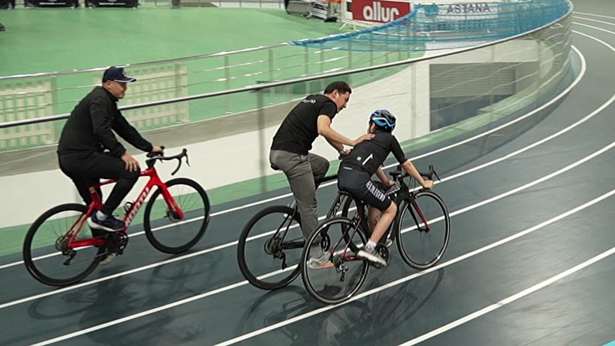 ** Young boy with autism riding adaptive bicycle with coach at training center in Kazakhstan