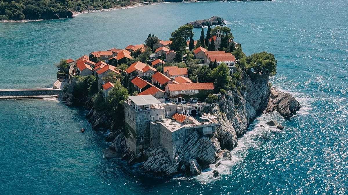 Aerial view of Sveti Stefan island resort connected to Montenegro mainland by sandy isthmus