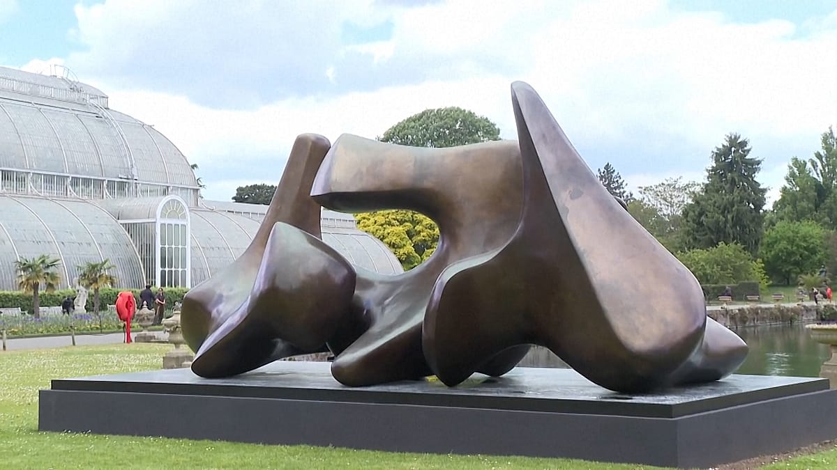 Large bronze Henry Moore sculpture standing among trees and gardens at London's Kew Gardens