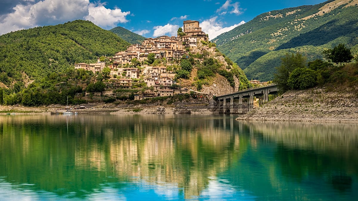Ancient stone pathway winding through historic Italian hillside town with medieval architecture