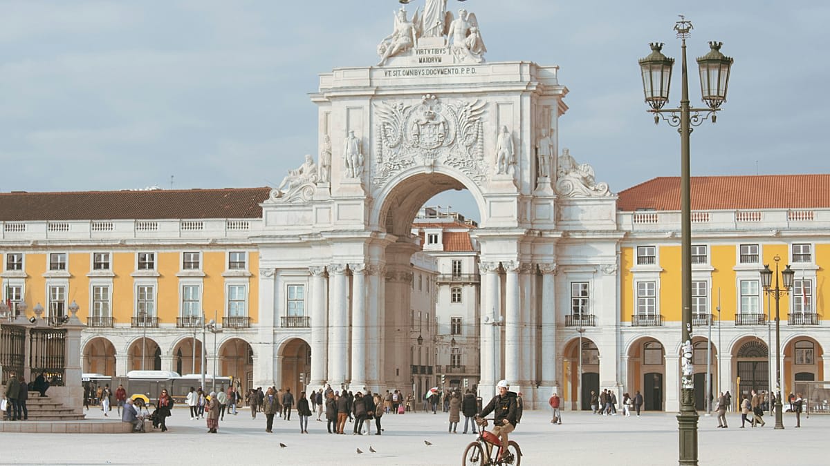 Colorful historic buildings and terracotta rooftops overlooking Lisbon's scenic waterfront on a sunny day