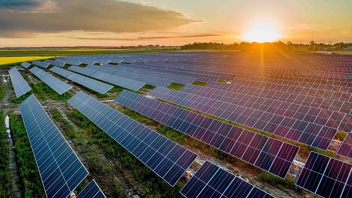 Wind turbines and solar panels generating clean electricity across Lithuanian countryside landscape