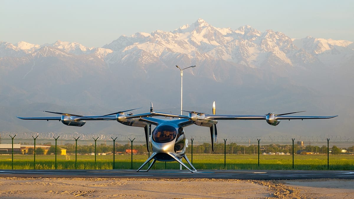 White electric air taxi aircraft hovering during test flight in Kazakhstan mountains