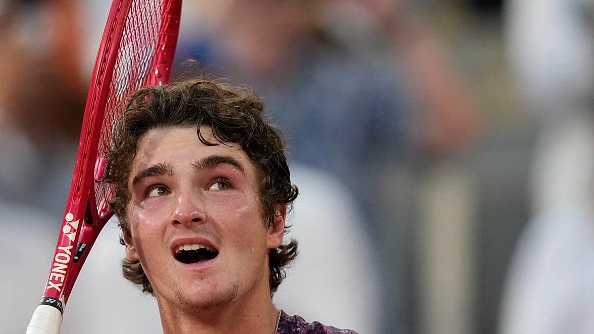 Young Brazilian tennis player João Fonseca celebrating victory on clay court at French Open