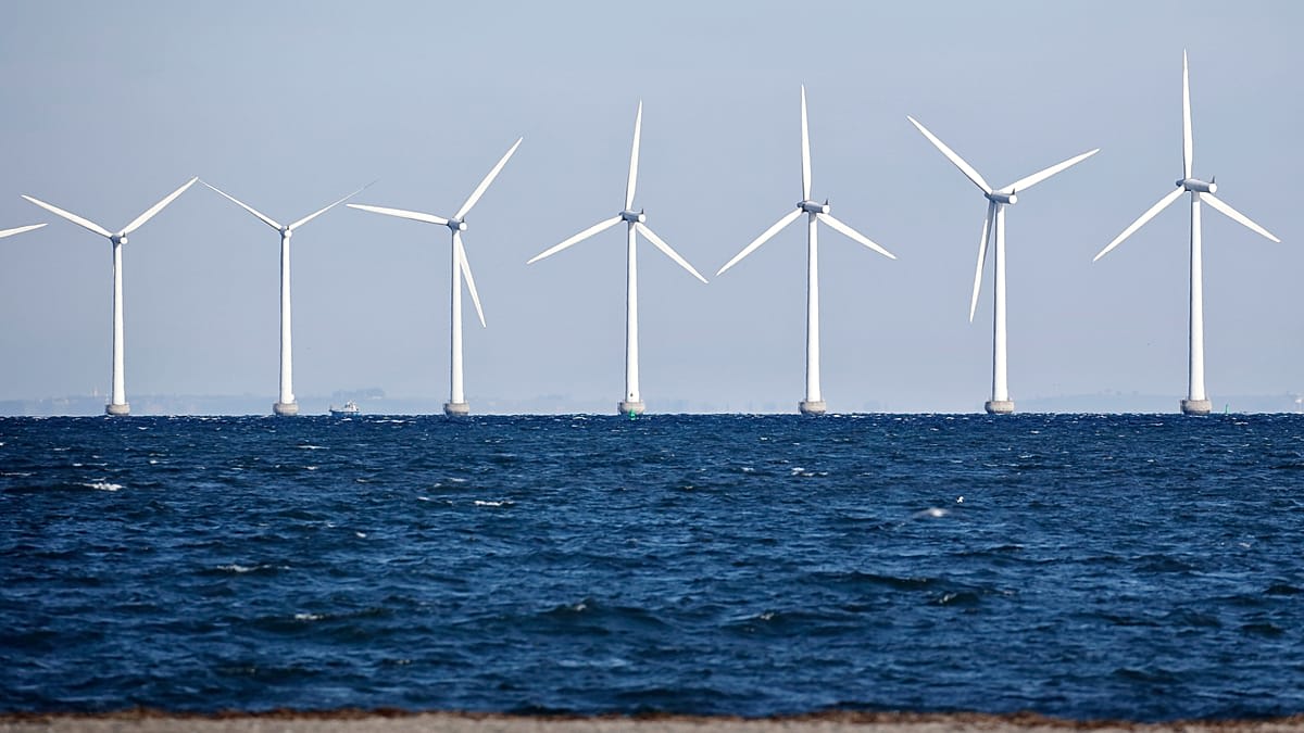 Offshore wind turbines standing tall in the Baltic Sea against a bright sky