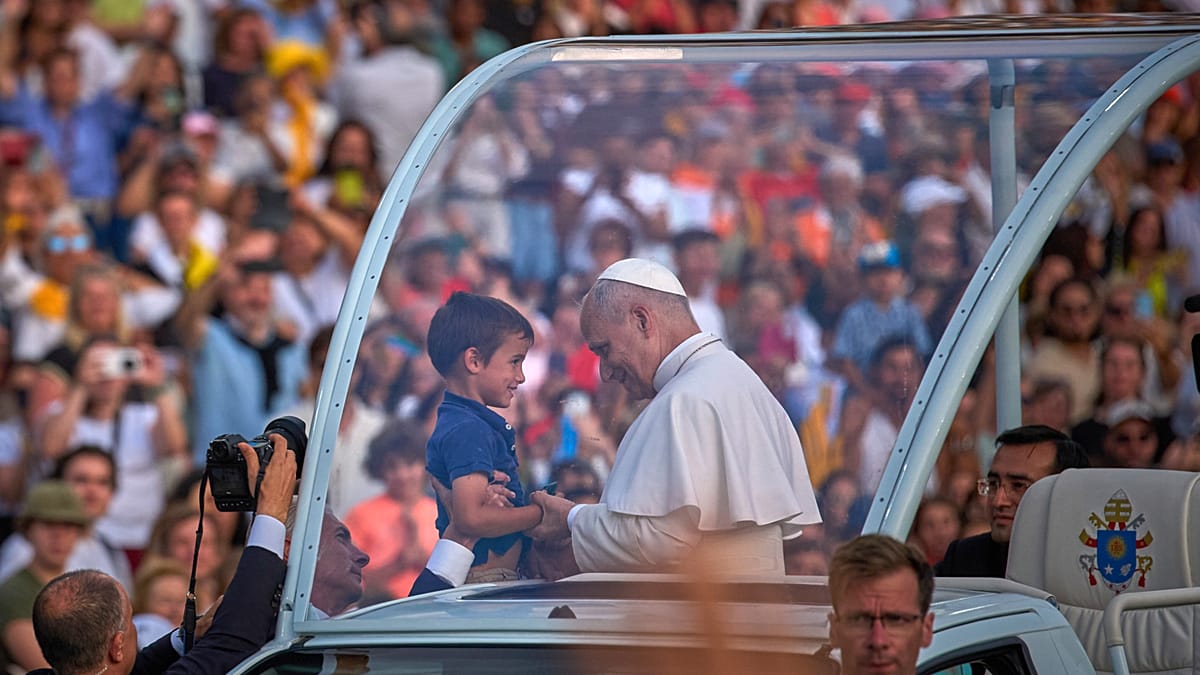 Pope Leo XIV holding hands and smiling with young boy Joaquim during Barcelona visit