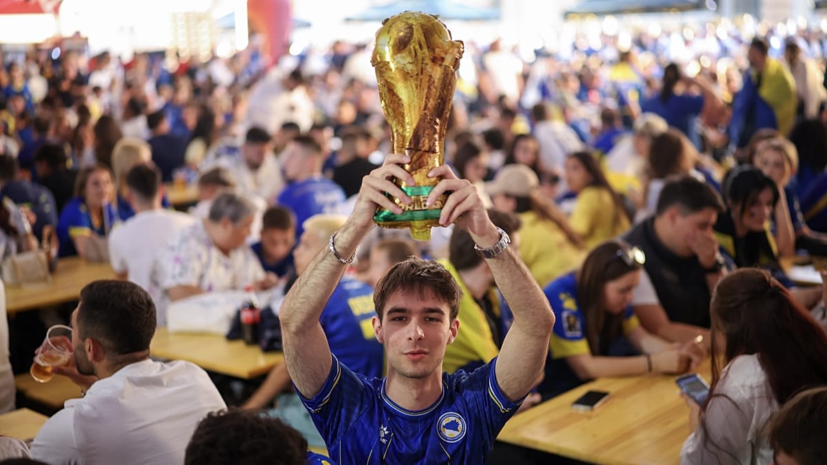 Bosnian football fans in blue jerseys celebrating and singing at World Cup stadium