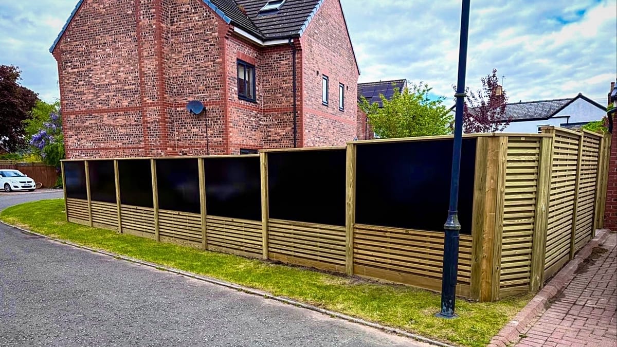 Modern garden fence with integrated vertical solar panels generating electricity in European backyard