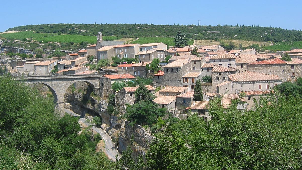 Stone cave dwelling carved into hillside in Trôo village, France, with entrance and windows visible