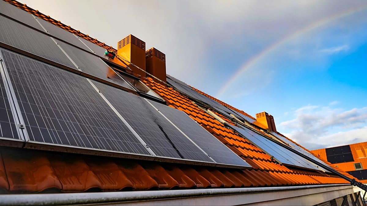 Rooftop solar panels on suburban home with blue sky and bright sunshine overhead
