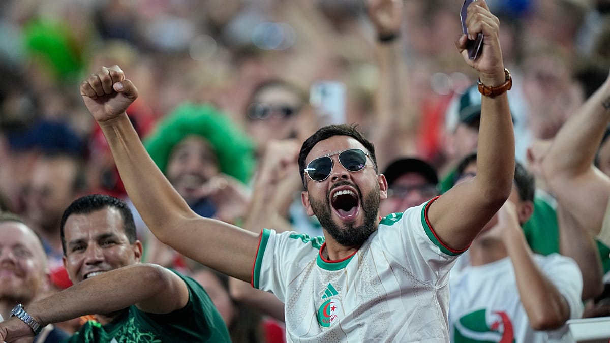 ** Algerian football fans celebrating in streets of Algiers waving national flags after World Cup advancement