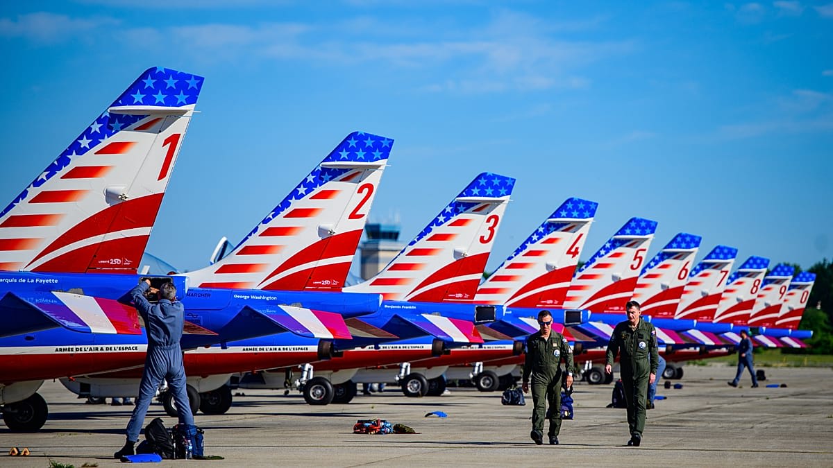 French Alpha Jets flying in formation over Manhattan skyline trailing red white and blue smoke