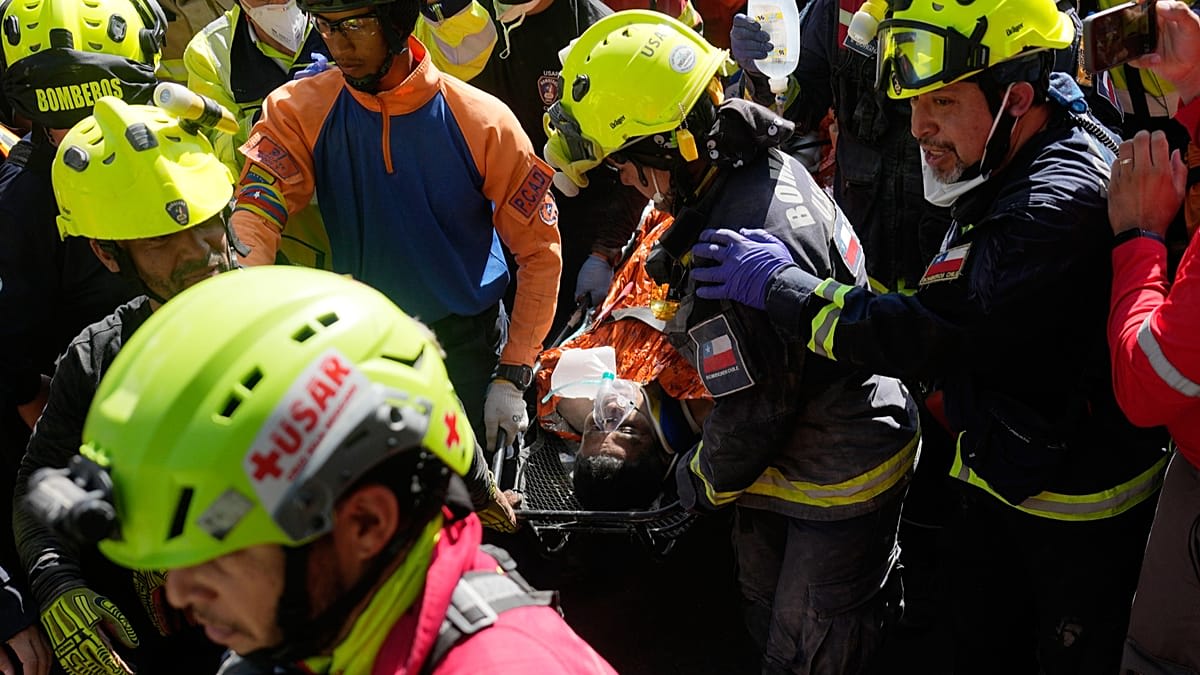 Rescue workers carry Hernán Alberto Gil Flores on stretcher after eight-day rescue operation in Venezuela