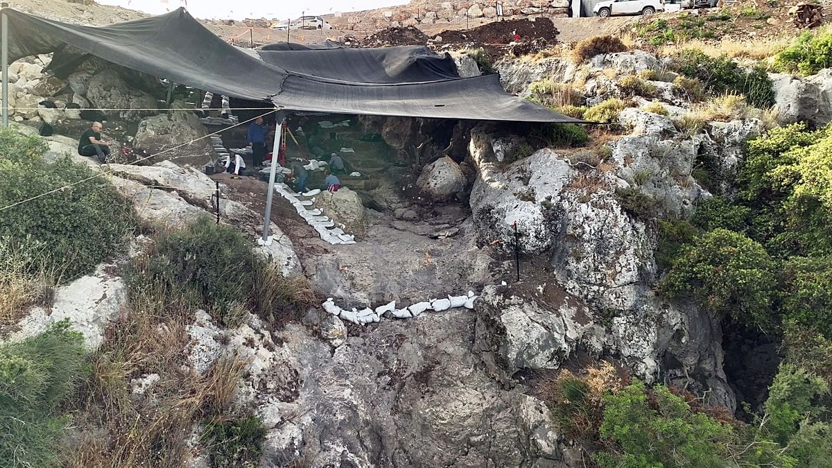 Archaeologists excavating inside ancient sealed cave in northern Israel showing preserved prehistoric layers