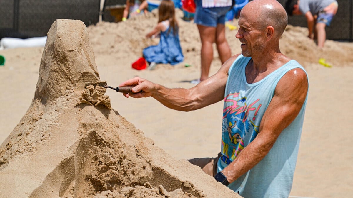 Artists sculpting giant marine animals from sand on Croatian beach during annual summer festival