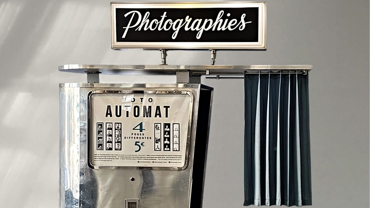 Person pulling back curtain of vintage black and white photo booth in classic style