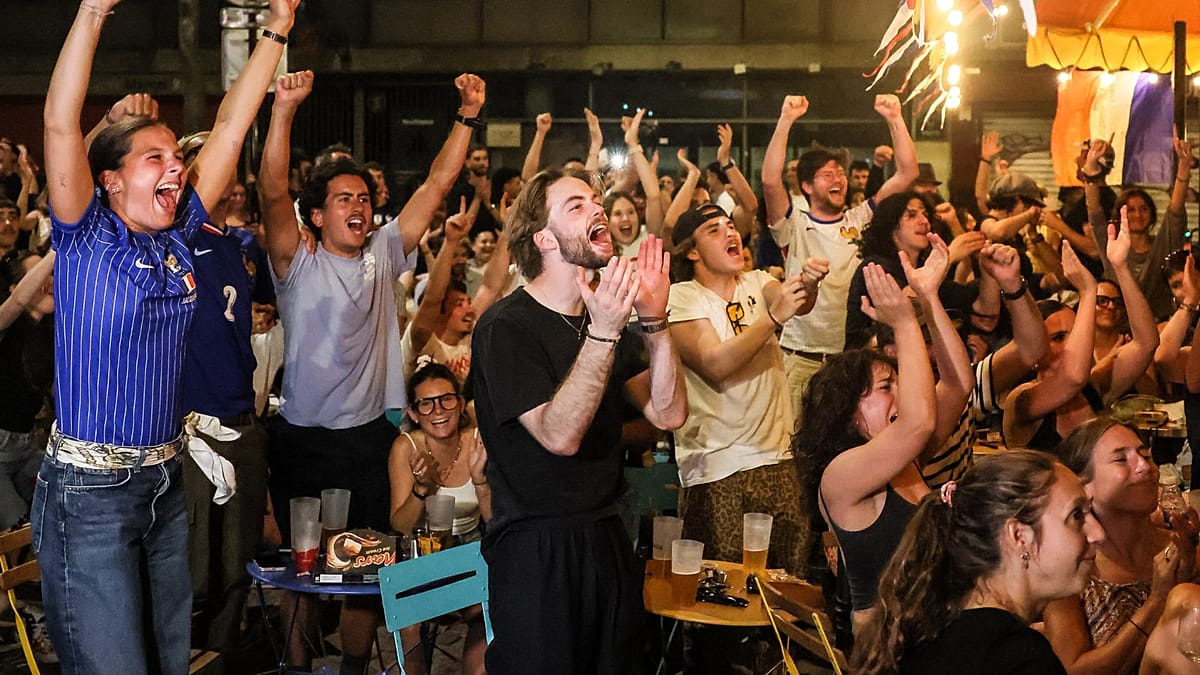 French soccer fans waving flags and celebrating in Paris streets after World Cup victory