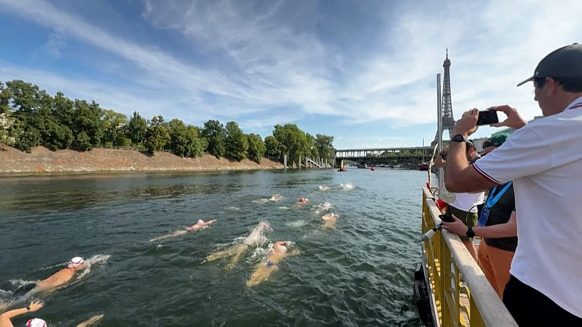 Swimmers racing through Paris's Seine River with Eiffel Tower visible in background