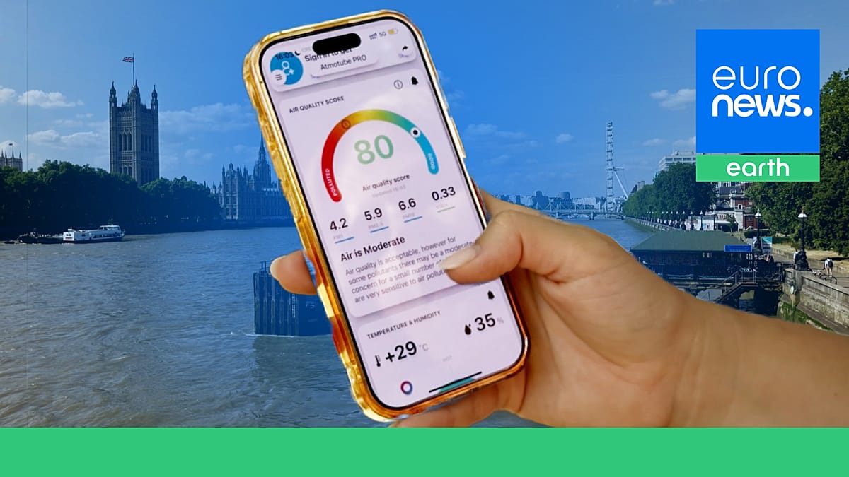 Compact black air quality sensor mounted on urban street pole in London neighborhood