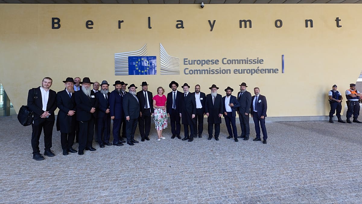 Rabbis and EU officials sitting together at conference table in Brussels meeting room