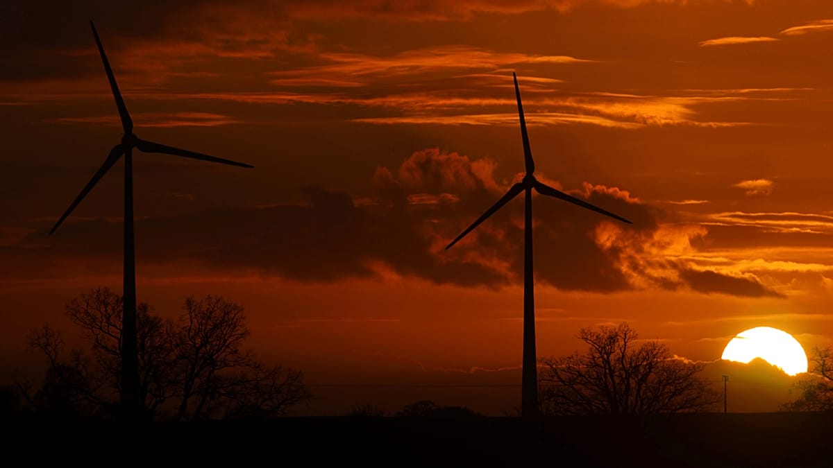 Solar panels and wind turbines generating clean electricity under bright blue European sky