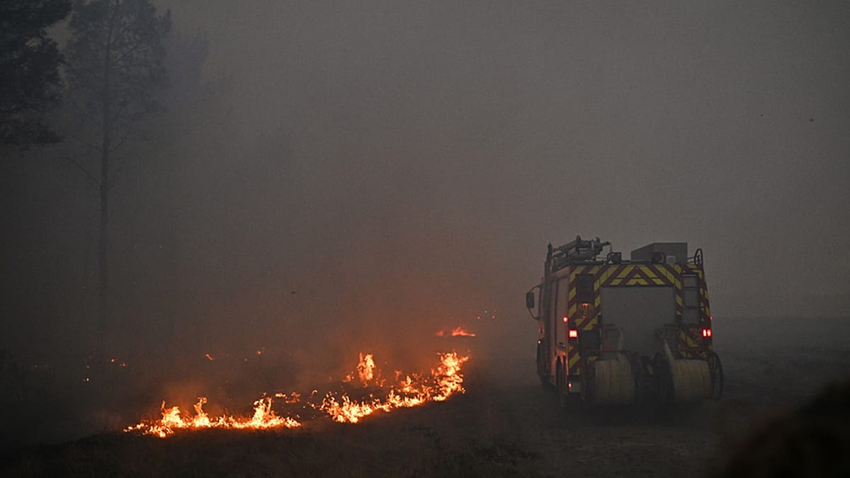Firefighters using strategic barriers to protect community from approaching wildfire