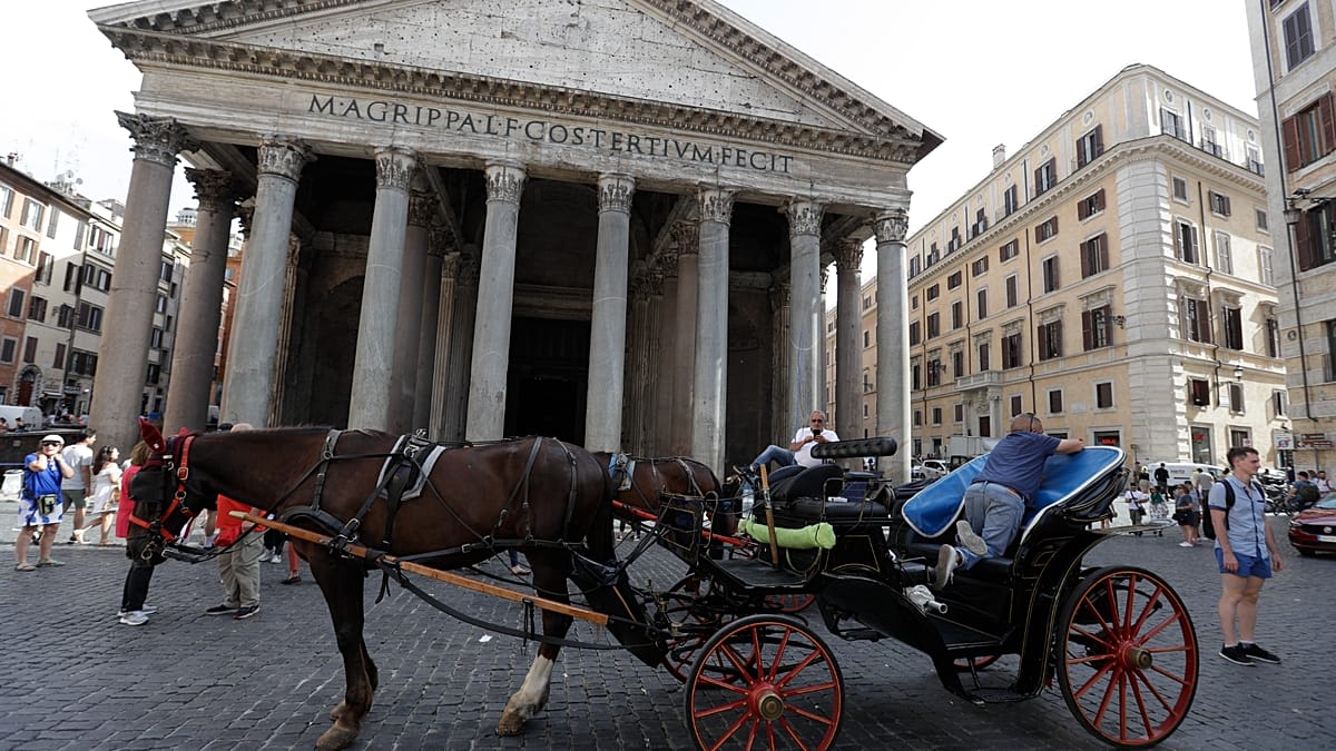 Traditional horse-drawn botticella carriage on cobblestone street in historic Rome, Italy