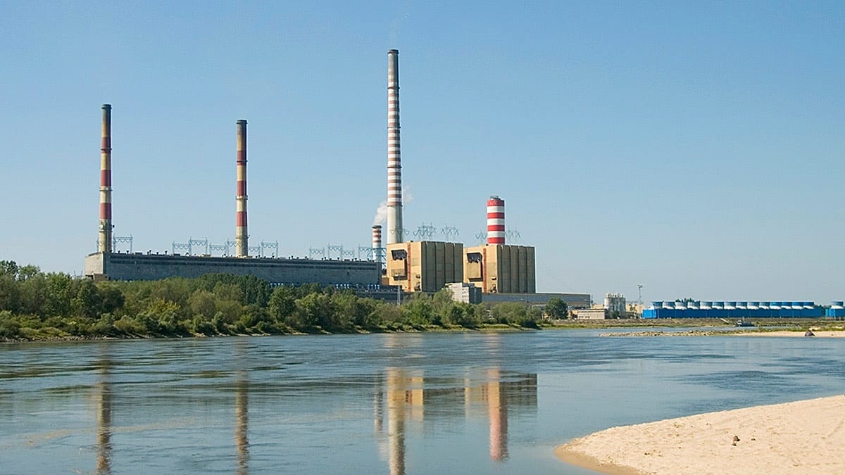 ** Solar panels gleaming under bright sun with dried riverbed visible in background