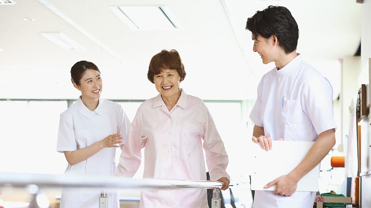 Person with Parkinson's disease exercising with physical therapist in bright rehabilitation facility
