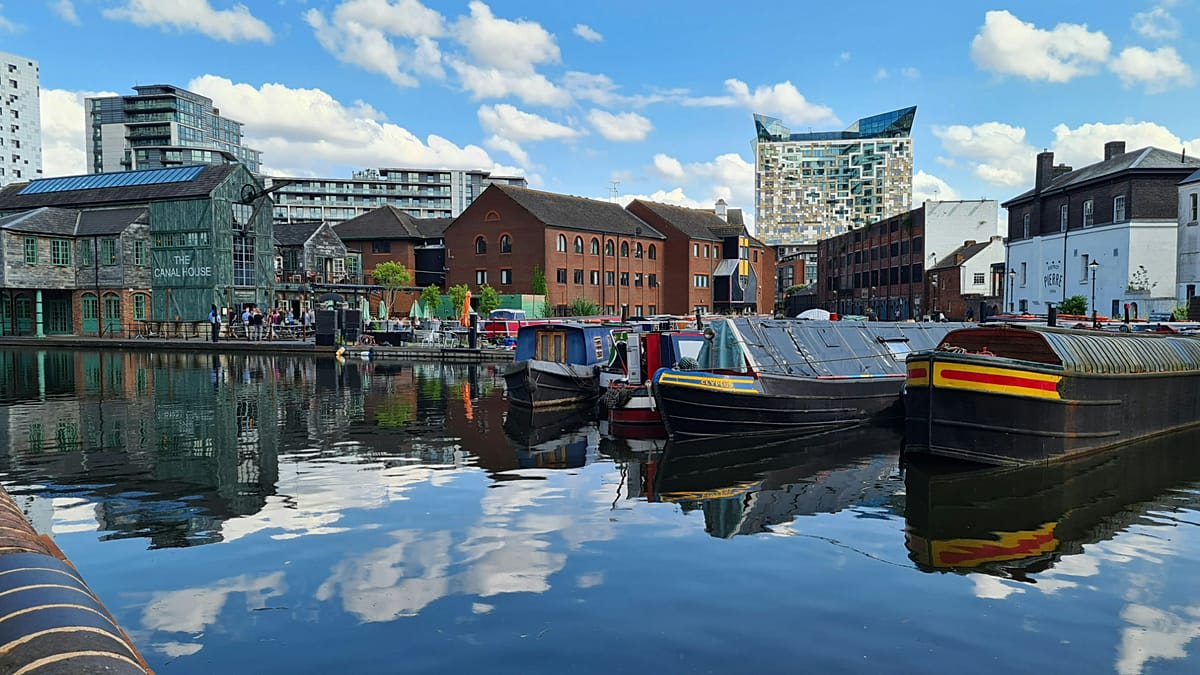 Historic canal-side warehouses line Hamburg's Speicherstadt district under blue sky