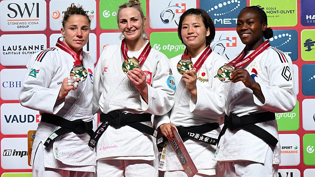 Judo athletes competing on blue competition mat during Lausanne Grand Slam tournament in Switzerland