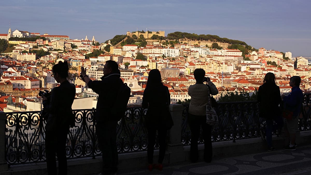 ** Lisbon cityscape showing São Jorge Castle overlooking the Tagus River with modern buildings