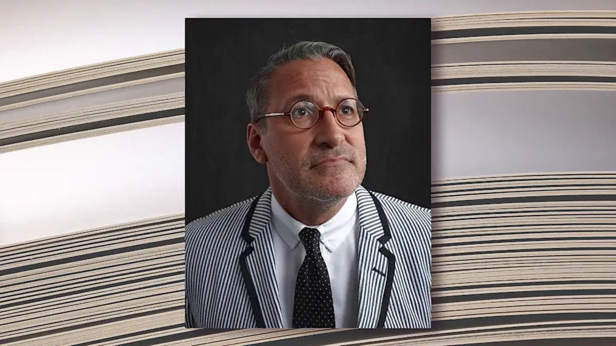 Graphic designer Chip Kidd working at desk with book covers and design materials