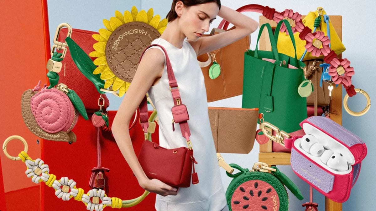 Colorful handcrafted leather charm collection featuring flowers, bumblebee, and garden designs clipped to handbag