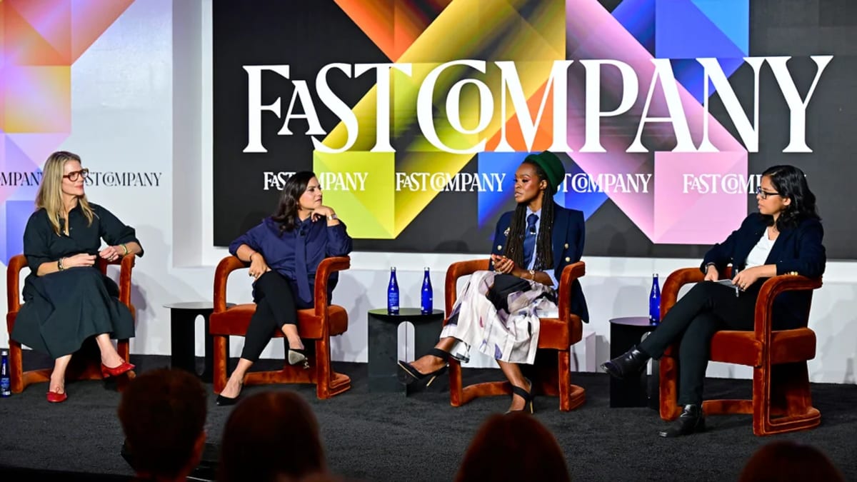Professional mothers in business attire having discussion at leadership conference panel