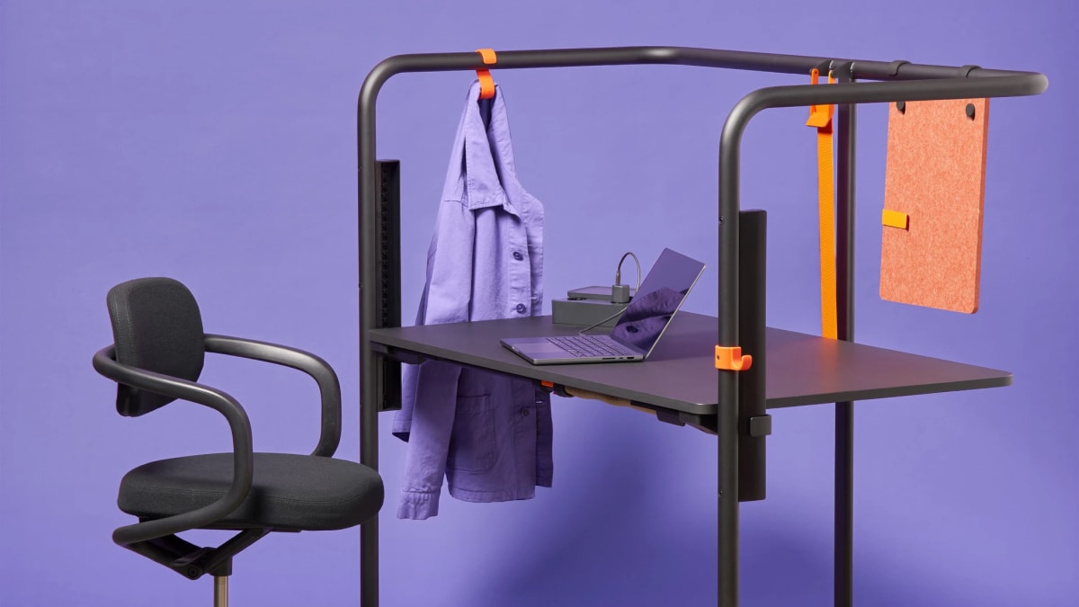 Modern minimalist office desk with metal frame and trapezoidal shape by designer Konstantin Grcic