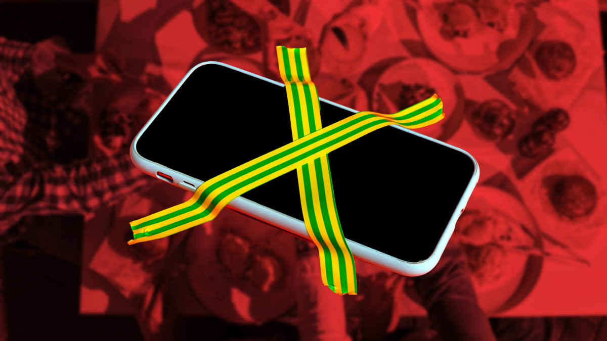 Friends laughing and talking together at restaurant table without phones in view