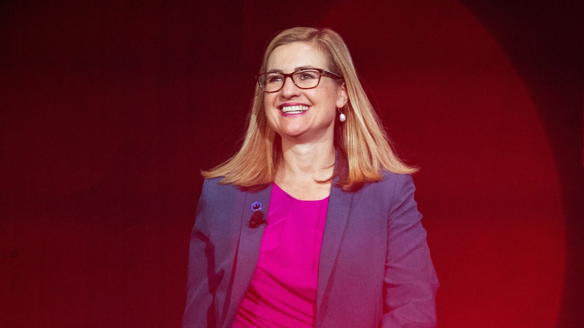 White Waymo autonomous vehicle driving on sunny Phoenix street with clear blue sky