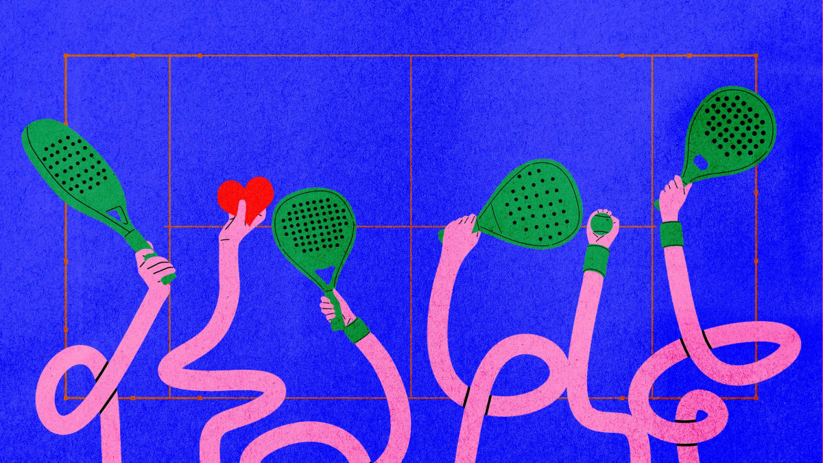 Two people playing padel on an outdoor court, smiling and holding racquets together