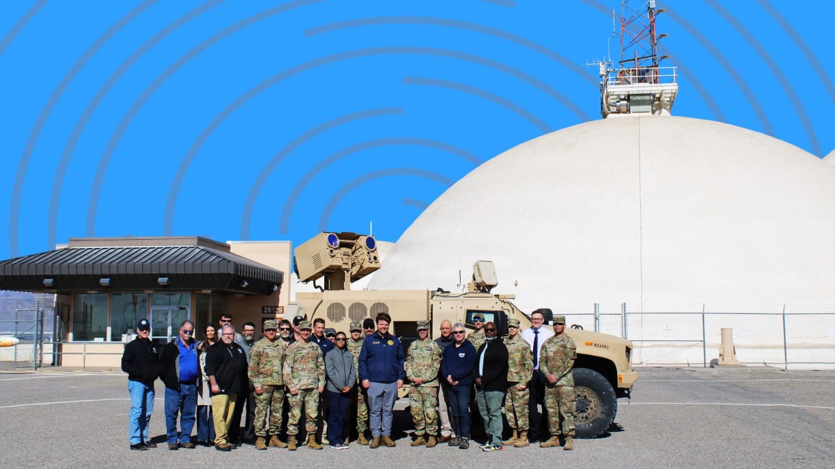 Military high-energy laser system mounted on vehicle pointing toward sky for drone defense