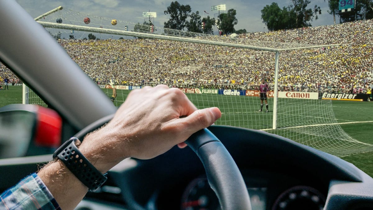 Person using smartphone navigation app inside large stadium with crowd in background