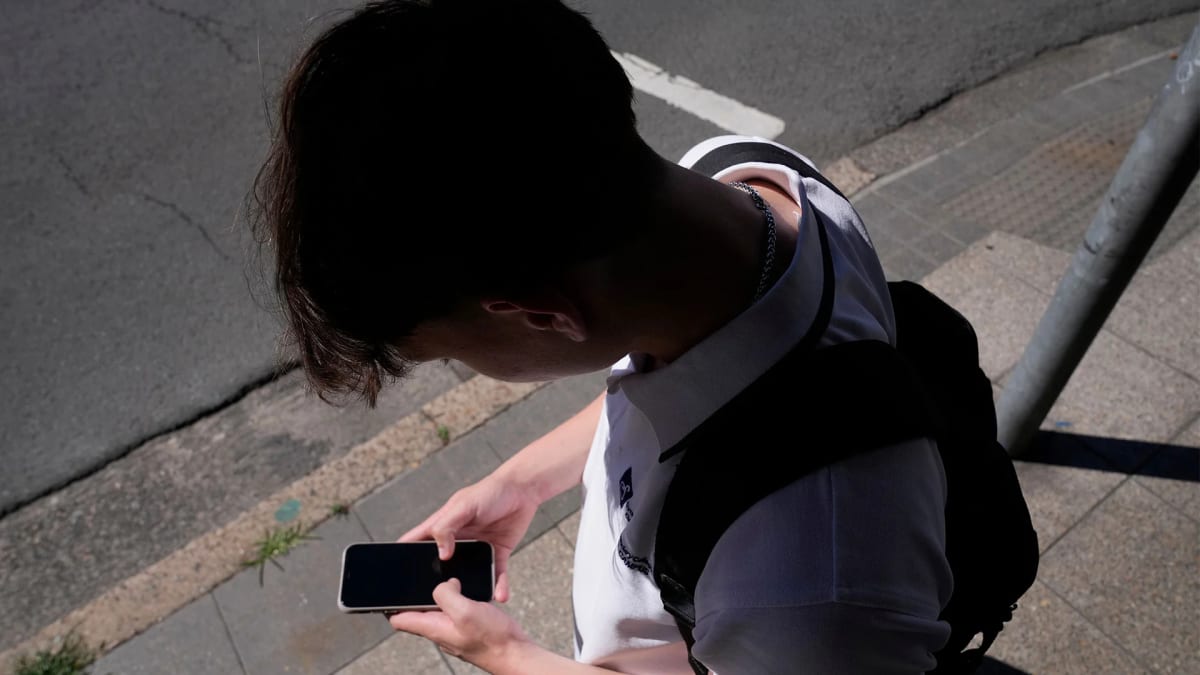 Person holding smartphone displaying social media feed with choice icons and settings overlay