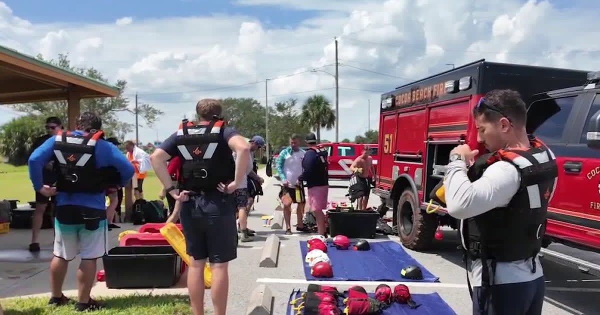 Firefighters in safety gear practice swift water rescue techniques in moving water at Titusville park